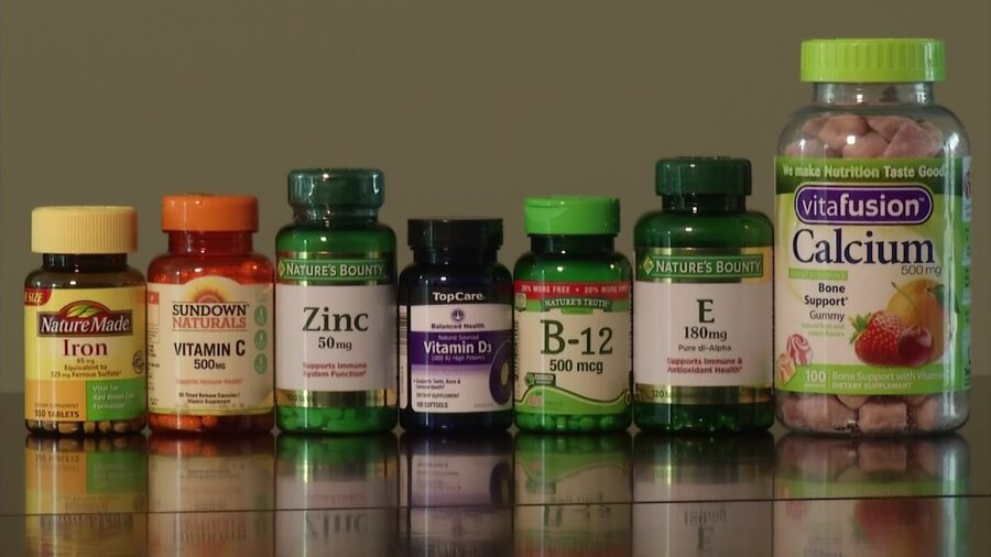 Vitamin and mineral supplement bottles lined up in a row at Unihealth Pharmacy.